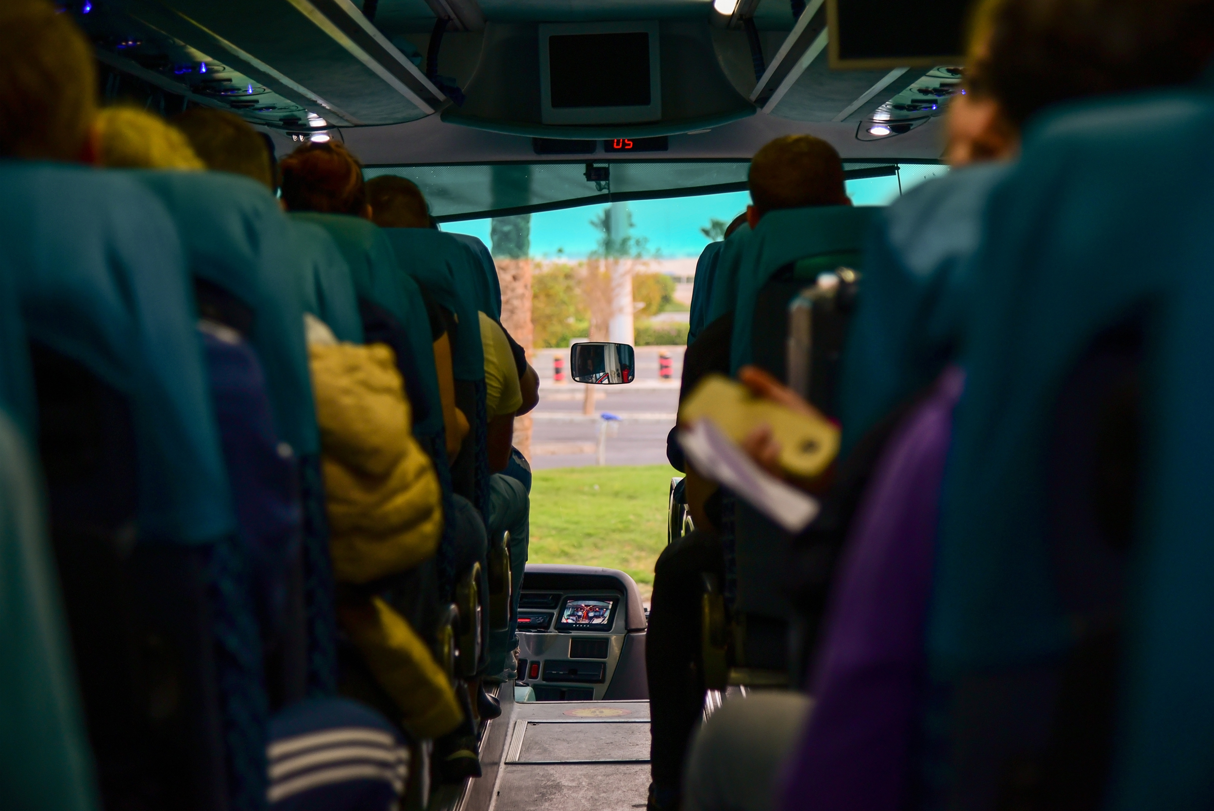 Passengers ride in a tourist bus on the seats.